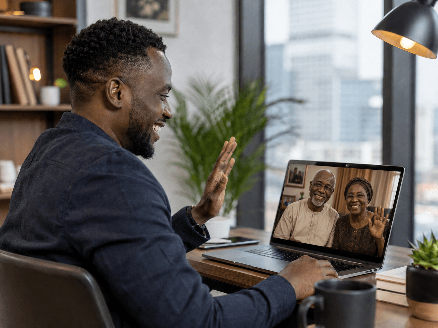 A diaspora family member video-calling parents back home from a laptop.
